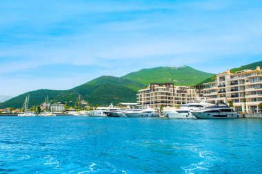 Tivat, Karadağ - 28 Haziran 2021: Porto Karadağ 'daki yat marinasının deniz kenarındaki konutları ve güzel gezinti alanlarıyla gün batımı manzarası