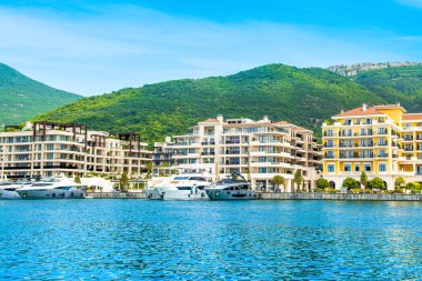 Tivat, Karadağ - 28 Haziran 2021: Porto Karadağ 'daki yat marinasının deniz kenarındaki konutları ve güzel gezinti alanlarıyla gün batımı manzarası