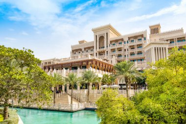 Dubai, Birleşik Arap Emirlikleri - 24 Nisan 2022: Dubai 'deki en ünlü tatil beldesi Madinat Jumeirah' da Arap tarzı binalar, kanallar ve tropikal manzaralı güzel bir lüks otel