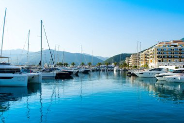 Tivat, Montenegro - June 18, 2022: Sunset landscape of the yacht marina in Porto Montenegro with waterfront residences and  the beautiful promenade