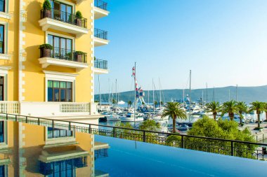 Tivat, Montenegro - June 18, 2022: View from infinity pool to the yacht marina in Porto Montenegro with waterfront residences and  the beautiful promenade 