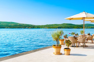 Mediterranean cafe on the shore of the Bay of Kotor - Boka Bay, with beautiful view to the coastline, Montenegro