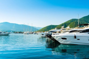 Tivat, Karadağ - 18 Haziran 2022: Porto Karadağ 'daki yat marinasının deniz kenarındaki konutları ve güzel gezinti alanlarıyla gün batımı manzarası
