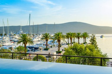 Tivat, Montenegro - June 18, 2022: Sunset landscape of the yacht marina in Porto Montenegro with waterfront residences and  the beautiful promenade - view from infinity pool