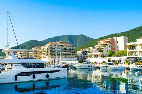 Tivat, Karadağ - 18 Haziran 2022: Porto Karadağ 'daki yat marinasının deniz kenarındaki konutları ve güzel gezinti alanlarıyla gün batımı manzarası