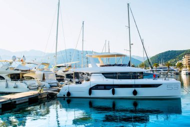 Tivat, Montenegro - June 18, 2022: Sunset landscape of the yacht marina in Porto Montenegro with waterfront residences and  the beautiful promenade