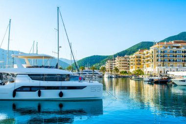 Tivat, Karadağ - 18 Haziran 2022: Porto Karadağ 'daki yat marinasının deniz kenarındaki konutları ve güzel gezinti alanlarıyla gün batımı manzarası