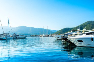 Tivat, Karadağ - 18 Haziran 2022: Porto Karadağ 'daki yat marinasının deniz kenarındaki konutları ve güzel gezinti alanlarıyla gün batımı manzarası