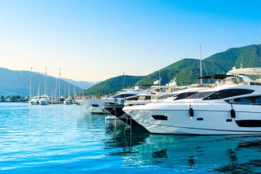 Tivat, Karadağ - 18 Haziran 2022: Porto Karadağ 'daki yat marinasının deniz kenarındaki konutları ve güzel gezinti alanlarıyla gün batımı manzarası
