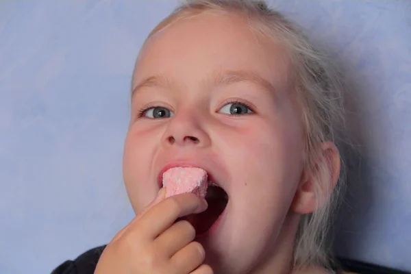 Menina bonita comendo carne doce — Fotografia de Stock