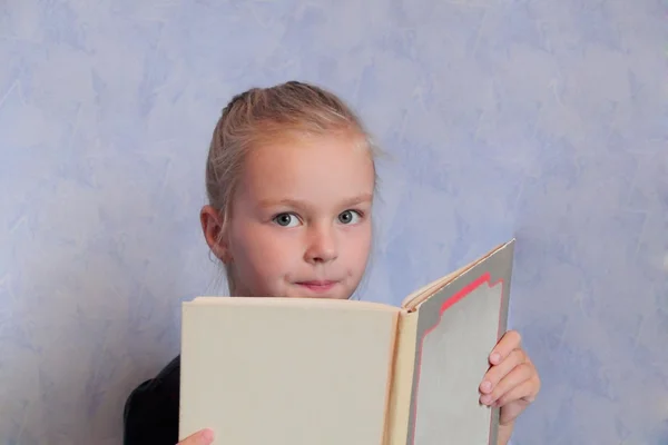 Menina com cabelo loiro lendo um livro — Fotografia de Stock