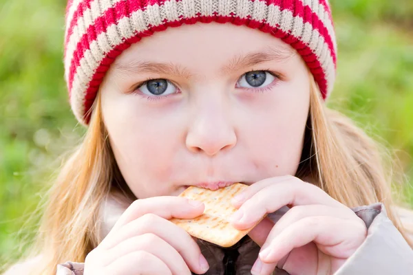 Fille en automne manger cookie — Photo