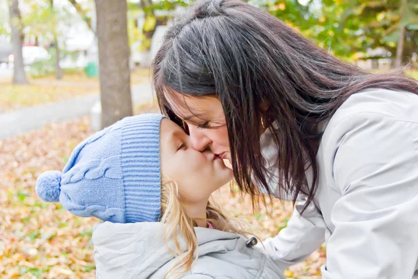 Мать и дочь целуются осенью — стоковое фото