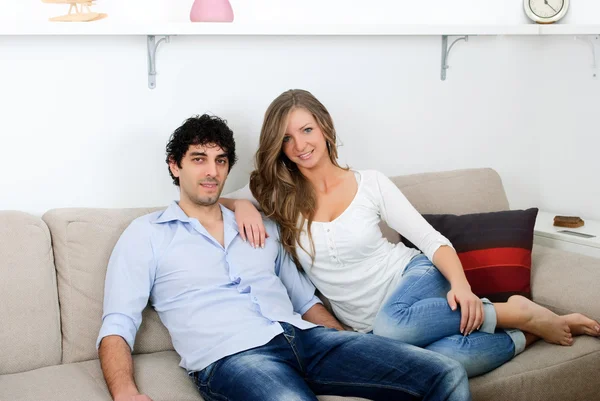 Young couple sitting in living room — Stock Photo, Image