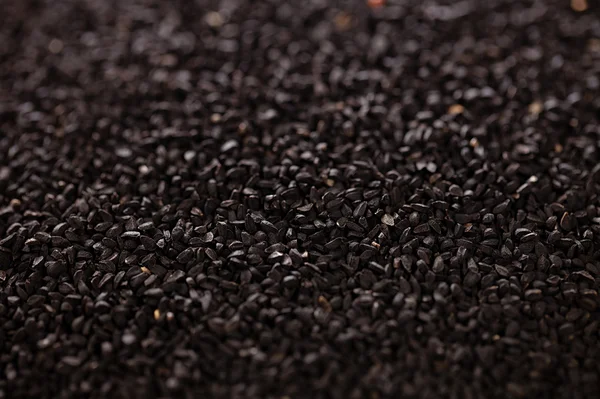 Black cumin or caravay or onion seeds backdrop, shallow dof — Stock Photo, Image