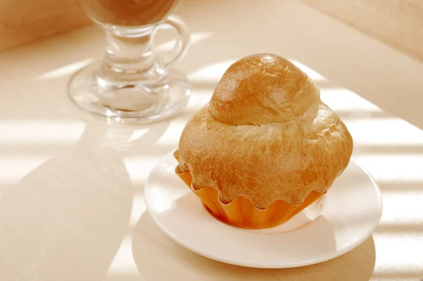 Frans brioche en witte kopje koffie op achtergrond — Stockfoto