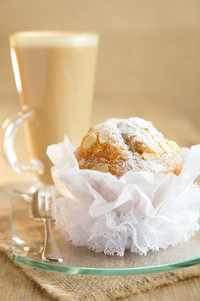 Elegante muffin de almendras y café con leche en el fondo — Foto de Stock