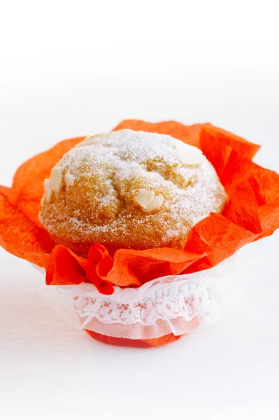Muffin de almendras festivo con envoltura roja sobre mesa blanca , — Foto de Stock