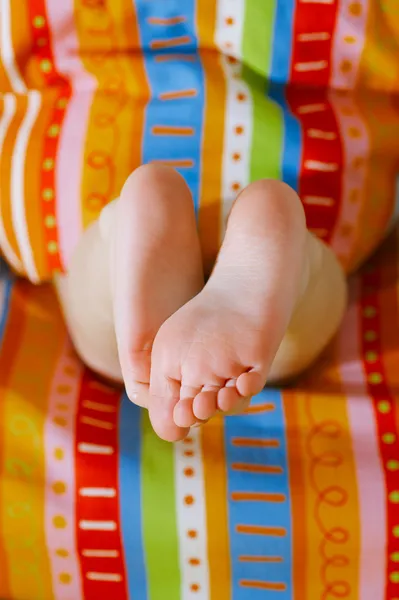 Toddlers girl feet in a bed under the morning sun — Stock Photo, Image