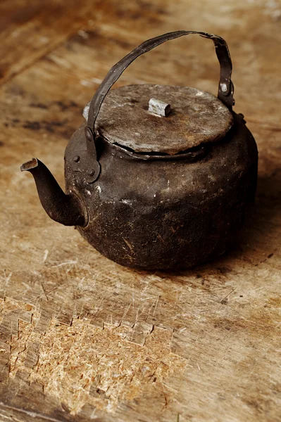 Rußige alte Teekanne auf altem Tisch in offener Küche — Stockfoto