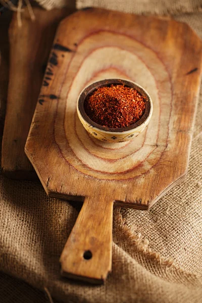 Chiles rojos picantes escamas de pimienta en el tazón en backgro tablero de madera — Foto de Stock