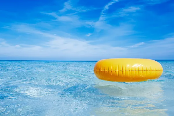 Schwebender gelber Ring auf kristallblauem Meerwasser mit Himmel, flach — Stockfoto