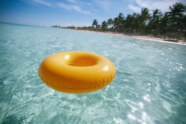 Плавающее кольцо на голубом чистом море с пляжем, мелководье dof — стоковое фото
