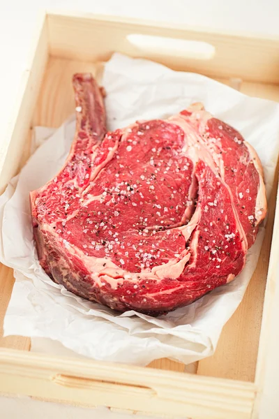 Bife de bife em papel e mesa de madeira — Fotografia de Stock