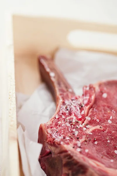 Bone-in Rib eye Steak steak on paper and wooden table — Stock Photo, Image