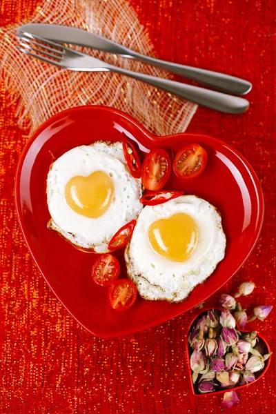 Fried egg with heart shape yolks and rose tea — Stock Photo, Image