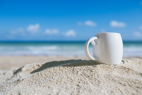 Λευκό εσπρέσο καφέ Κύπελλο με τον ωκεανό, την παραλία και την Θαλασσογραφία Φωτογραφία Αρχείου