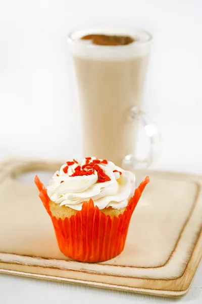 Červené slavnostní muffin a kávu latte ve sklenici na dřevěné desce — Stock fotografie