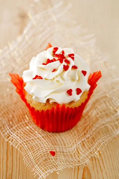 Muffin festivo vermelho com doces de coração e madeira — Fotografia de Stock