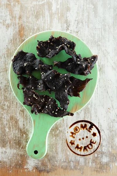 Jerky beef - homemade dry cured spiced meat with stamp on wood — Stock Photo, Image