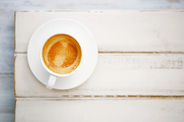 Кофе эспрессо в белой чашке на старом деревенском столе — стоковое фото