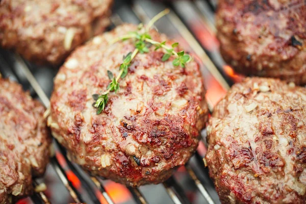 Eten vlees - rundvlees hamburgers op BBQ-barbecue grill met vlam — Stockfoto