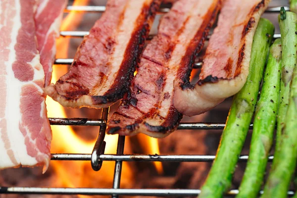 Bacon meat on bbq barbecue grill with fire — Stock Photo, Image