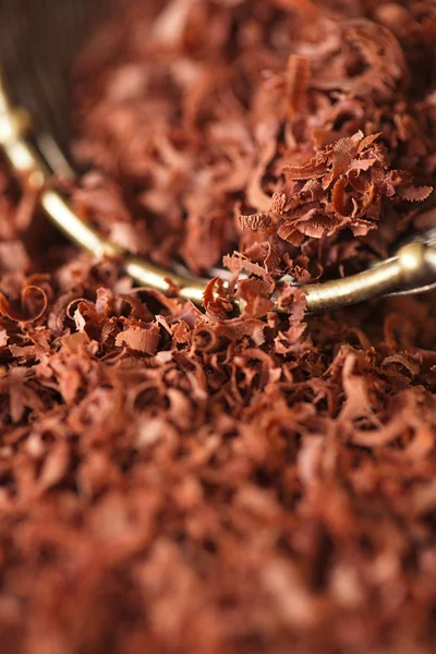 Fine grated chocolate 100 percent dark in sieve , shallow dof — Stock Photo, Image