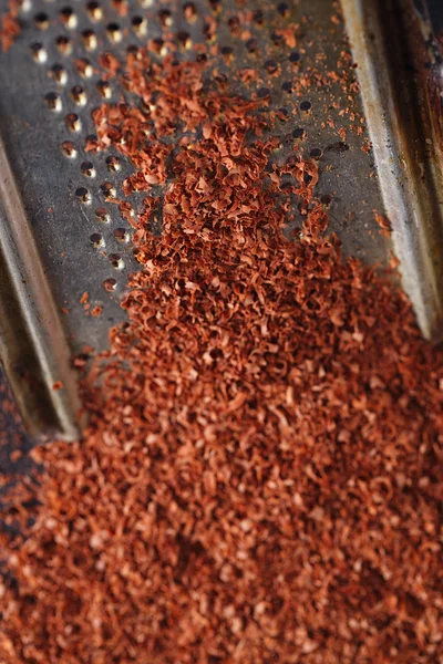 Fine grated chocolate on grater , shallow dof — Stock Photo, Image