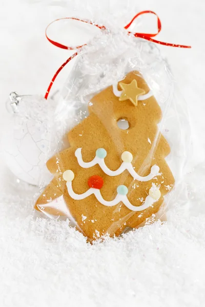 Gingerbread tree cookie in a bag on white snow background — Stock Photo, Image