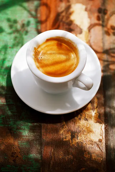 Tazza di caffè espresso su tavolo rustico con sole — Foto Stock