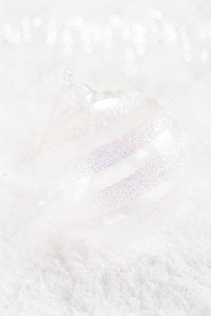 clear glass ball christmas decoration on white snow background
