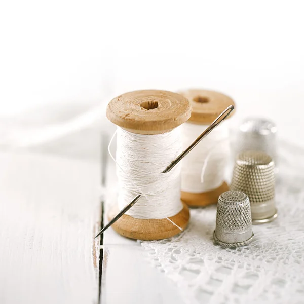 Real old reels spoons treads with needle and thimble on white wo — Stock Photo, Image