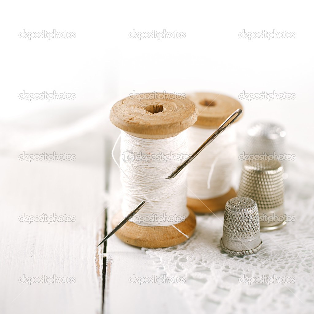 Real old reels spoons treads with needle and thimble on white wo