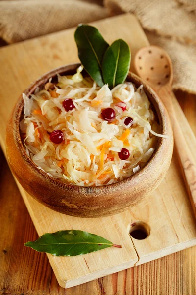 Sauerkraut - Sour cabbage - on wooden bowl with bay leaves — Stock Photo, Image