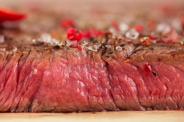 Beef steak on a wooden board and table — Stock Photo, Image