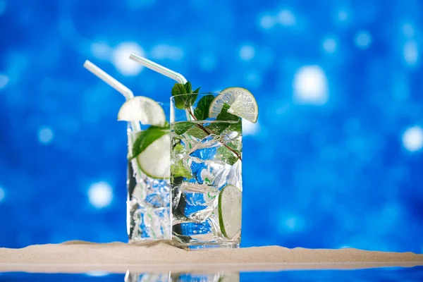mojito cocktail on beach sand and tropical seascape