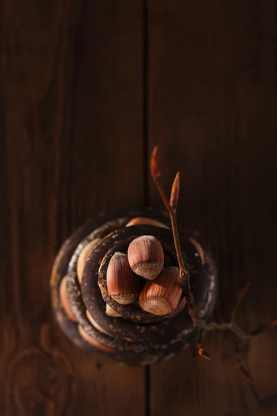 Wild hazelnut in iron bowls stacked on wooden table — Stock Photo, Image