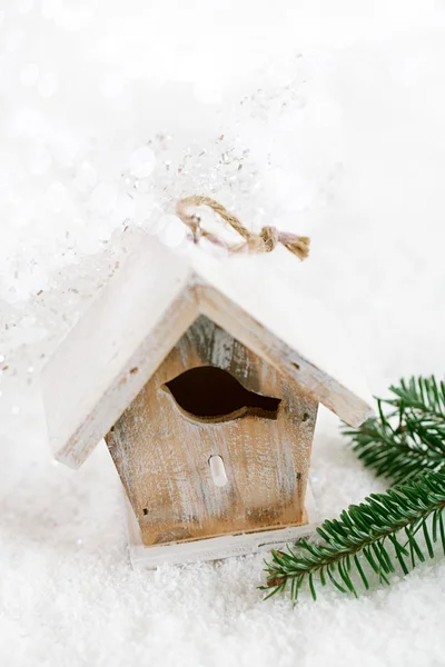 Trä fågel hus Juldekoration på vit snö bakgrund — Stockfoto