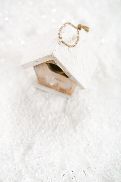Trä fågel hus Juldekoration på vit snö bakgrund — Stockfoto